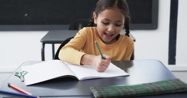 Der Schule Konzentriert Sich Ein Junges Mädchen Auf Das Schreiben — Stockvideo