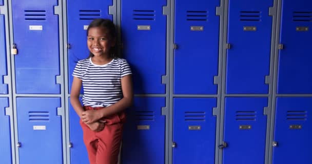 Koulun Käytävässä Nuori Afroamerikkalainen Tyttö Nojaa Sinisiin Kaappeihin Joissa Kopiotilaa — kuvapankkivideo