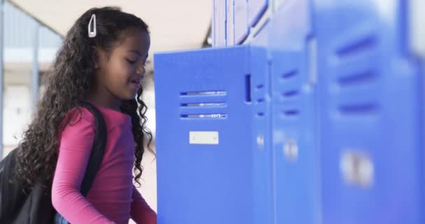 Koulun Käytävässä Nuori Afroamerikkalainen Tyttö Nojaa Siniseen Kaappiin Hänellä Kiharat — kuvapankkivideo