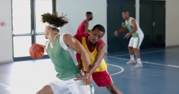 一群朋友正在一个室内场地打篮球 这支多样化的球队包括非裔美国人和白人男子 他们都穿着运动服 表现出团队精神 没有改变 — 图库视频影像