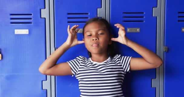Pasillo Escuela Una Joven Birracial Hace Una Cara Juguetona Ella — Vídeo de stock