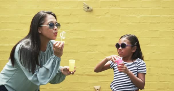 Biracial Äiti Tytär Aurinkolasit Puhaltavat Kuplia Molemmat Käyttävät Aurinkolaseja Rentoja — kuvapankkivideo