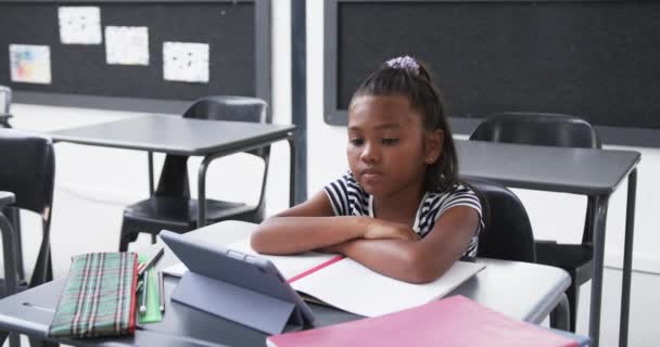 Koulun Luokassa Nuori Afroamerikkalainen Tyttö Keskittyy Tablettiin Hänellä Tummat Hiukset — kuvapankkivideo