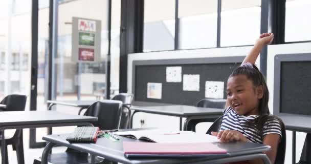 Koulun Luokkahuoneessa Nuori Afroamerikkalainen Tyttö Nostaa Kätensä Innokkaasti Kopioimalla Tilaa — kuvapankkivideo