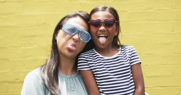Madre Hija Biracial Posando Divirtiéndose Contra Fondo Amarillo Aire Libre — Vídeo de stock