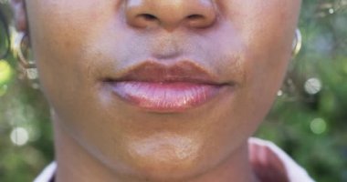Afro-Amerikalı bir kadının gülüşüne yakından bakınca parlayan beyaz dişleri ortaya çıkıyor. Bireyin pürüzsüz bir teni, dolgun dudakları var ve Afrika kökenli, değişmemiş, ağır çekimde....