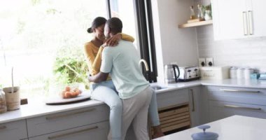 Çeşit çeşit bir çift modern bir mutfakta sevgi dolu bir anı paylaşıyor, sarılıyorlar. Afrikalı Amerikalı koca, İspanyol karısını kucaklıyor. İkisi de gelişigüzel giyinmiş, değişmemiş, ağır çekimde..