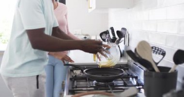 Çeşitli bir çift, parlak bir mutfakta birlikte kahvaltı hazırlıyor. Afrika kökenli Amerikalı koca tavaya vuruşunu yaparken, Kafkasyalı kadın da ona yardım ediyor, ikisi de gelişigüzel giyinmiş, değişmemiş.