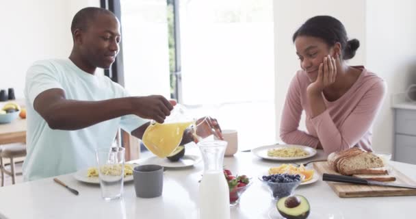 Afroamerikanskt Par Njuter Frukost Tillsammans Hemma Köket Maken Häller Saft — Stockvideo