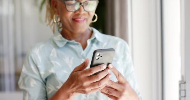 Een Afro Amerikaanse Senior Vrouw Lacht Thuis Naar Haar Telefoon — Stockvideo