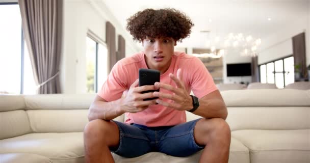 Joven Birracial Molesto Estresado Hombre Está Sentado Sofá Color Crema — Vídeo de stock