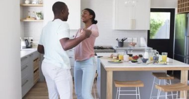 Çeşitli bir çift, neşeli bir anı paylaşıyor. Parlak bir mutfakta dans ediyorlar. Afrika kökenli Amerikalı koca ve karısı, her ikisi de genç, sevgi dolu gülümsemelerle sarılıyorlar, kahvaltı yayılmış, değişmemiş.