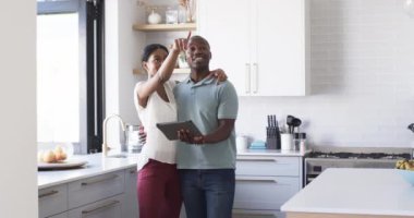 Tablet kullanan ve fotokopi alanı olan farklı bir çift. Kadın Asya 'lı, uzun siyah saçlı, elinde tablet var, adam ise Afro-Amerikan, geniş, değişmemiş, yavaş çekim gülümsüyor..