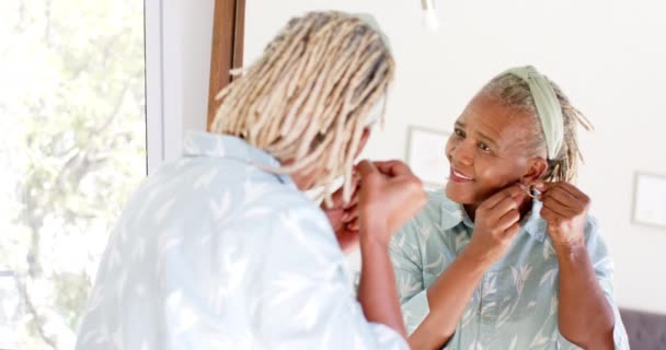Старшая Афроамериканка Надевает Серьги Смотрит Зеркало Свою Спальню Дома Неё — стоковое видео