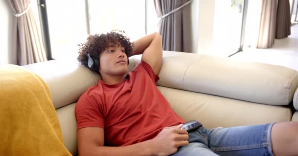 Ein Junger Mann Entspannt Sich Hause Auf Einem Sofa Mit — Stockvideo