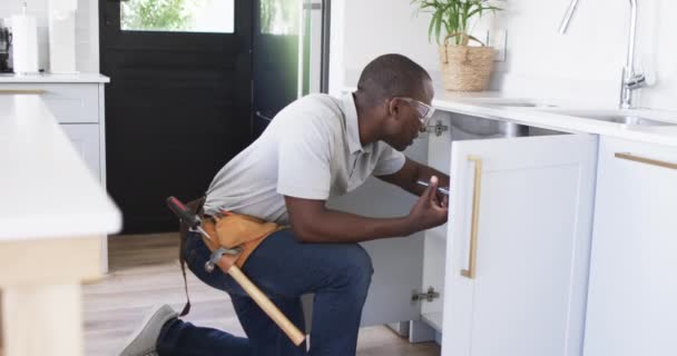 Afroameričtí Instalatéři Opravují Kuchyňský Dřez Nosí Opasek Nářadím Zkoumá Vnitřek — Stock video