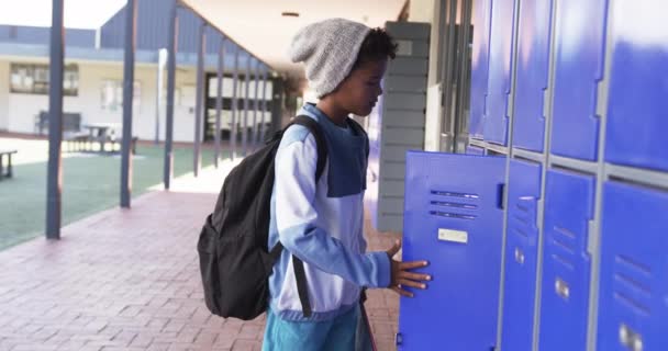 Шкільному Коридорі Молодий Афроамериканський Студент Стоїть Синіх Шафках Копіювальним Простором — стокове відео