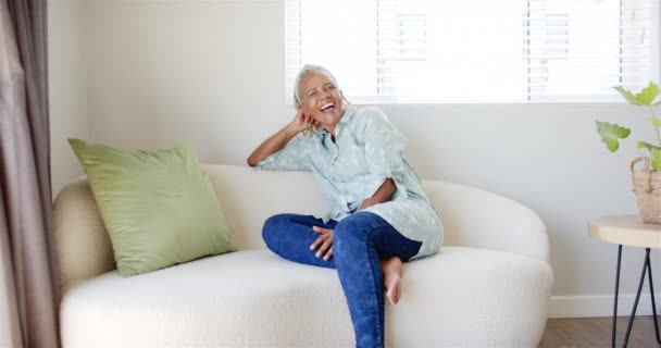 Старшая Афроамериканка Расслабляется Дома Кремовом Диване Короткие Седые Волосы Сияющая — стоковое видео