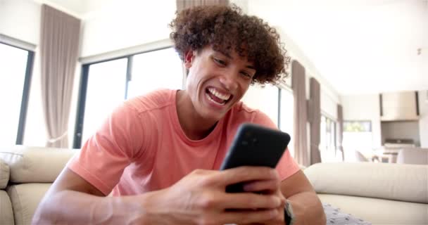Joven Birracial Está Comprometido Con Teléfono Inteligente Sofá Casa Tiene — Vídeos de Stock