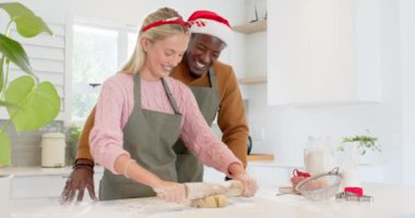 Çeşitli çiftler mutfakta birlikte Noel kurabiyesi pişiriyor, şen şakrak saç bantları takıyorlar. tatil, yemek pişirme, kutlama, birliktelik, ev yapımı