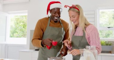 Noel zamanı, çeşitli çiftler mutfakta birlikte yemek pişiriyor, şenlikli şapkalar takıyor ve sıcacık gülümsüyorlar. Tatil, arkadaşlık, kutlama, birliktelik, yemek pişirme