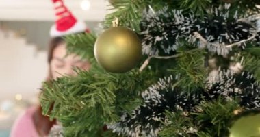 Noel ağacını altın süslerle süslemek, şenlik şapkası takan kadın, fotokopi odası. Tatiller, dekorasyon, kutlama, gelenek