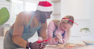 Birkaç Noel kurabiyesi dekore ediyor, gülümsüyor ve mutfakta tatil eğlencesi paylaşıyorlar. Pişirme, kutlama, festival, aile, yemek pişirme, Aralık
