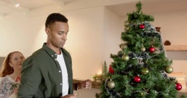 Gülen çift evde Noel ağacı süslüyorlar, bayram ruhunun tadını çıkarıyorlar, fotokopi çekiyorlar. Kutlama, dekorasyon