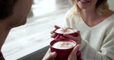 Noel zamanı evde sıcak kakao içen sevimli bir çift. tatil, sıcaklık, rahatlama, şenlik, aşk, kış