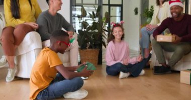 Çeşitli aileler evde hediyelerini veriyor, Noel 'i neşe ve kahkahalarla kutluyorlar. Kutlama, tatil, birliktelik, şenlik, dekorasyon, neşe