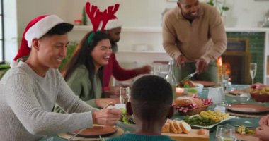 Çeşitli aileler Noel yemeğini birlikte yiyor, evde yemek ve kahkaha atıyorlar. Kutlama, çeşitli aile toplantıları, tatil, ziyafet, gelenek, kaynaşma