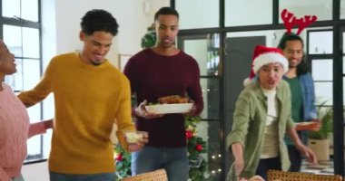 Çeşitli arkadaşlar Noel 'i evde kutluyor, sofrayı şenlikli tezahürat ve gülücüklerle kuruyor. Kutlama, dostluk, kış, neşe, birliktelik, tatil