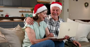 Noel Baba şapkası takmak, evde Noel boyunca dizüstü bilgisayarda video sohbeti yapmak. tatil, video çağrısı, şenlik, yaşlılık, teknoloji, kutlama