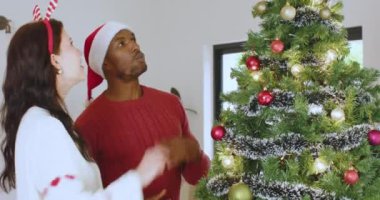 Noel ağacını süslerle süsleyen, gülümseyen ve Noel ruhunun keyfini çıkaran bir çift. Tatiller, kutlamalar, şenlik, aile, mevsimlik, kış