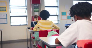 Okulda, öğrenciler masalarında oturur ve işlerine odaklanırlar. Eğitim, öğrenim, öğrenim, sınıf, öğrenciler, akademi