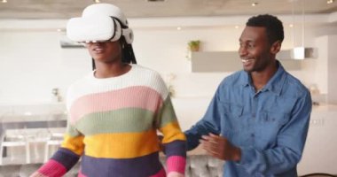 VR kulaklık kullanarak, kadın gülümserken erkek evde izliyor ve gülüyor. Teknoloji, sanal gerçeklik, eğlence, eğlence, rahatlama, etkileşim