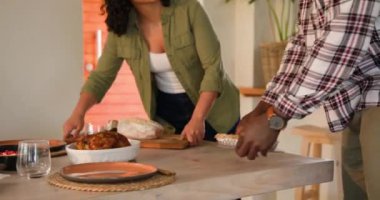 Gülümseyen çok ırklı çift evde pazar yemeği için sofra kuruyor, birlikteliğin tadını çıkarıyorlar. Aile, tatil, kutlama, sonbahar, yemek, gelenek