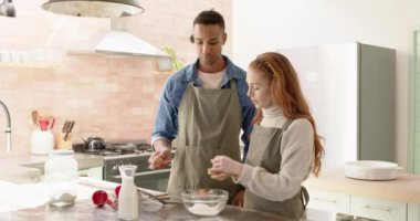 Mutlu çift mutfakta yumurta kırıyor, bayram eğlencesinin tadını çıkarıyor. Aşçılık, birliktelik, mutluluk, yerli, şenlikli