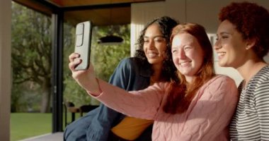 Selfie çekiyoruz, çeşitli bayan arkadaşlar gülümsüyor ve içeride eğleniyoruz. Arkadaşlık, birliktelik, mutluluk, çok kültürlü, kendi portresi, bağ.