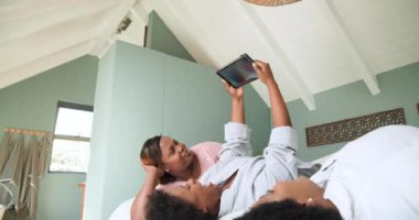 Evde, arkadaşlar birlikte tablet kullanıyor, keyifli anları paylaşıyor ve dinleniyorlar. Teknoloji, dostluk, rahatlama, rahatlama, oturma odası, birliktelik.