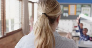 Okulda, bayan öğretmen sınıf tartışmasında öğrencileri el kaldırmaya çağırıyor. Eğitim, öğretim, öğrenme, etkileşim, katılım, akademik