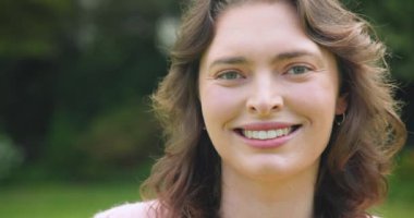 Neşeli bir şekilde gülen, güneşli bir günde parkta eğlenen, mutlu hisseden bir kadın. Mutluluk, doğa, güneş ışığı, rahatlama, rahatlama, özgürlük.