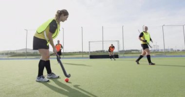 Dişi hokey oyuncuları sahada antrenman yapıyor, kararlılıkla kaleye doğru koşuyorlar. Spor, takım çalışması, yarışma, çim hokeyi, egzersiz, antrenman