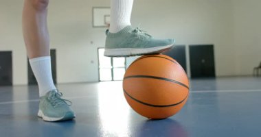 Basketbola ayak uyduran atlet kapalı sahada maça hazırlanıyor. Spor, performans, eğitim, kararlılık, hazırlık, eylem