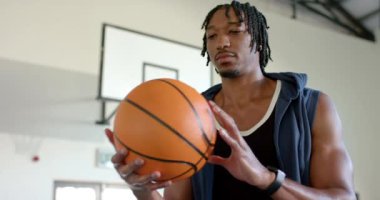 Parmak üzerinde dönen basketbol, kapalı spor salonunda pratik yapan bir adam. Spor, top tutma, atlet, antrenman, egzersiz