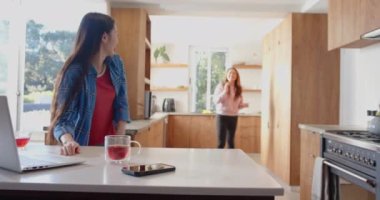 Mutfakta birlikte dans eden Asyalı anne ve kızı kaliteli vakit geçiriyorlar. Aile, bağ, ev, dans, mutluluk, eğlence