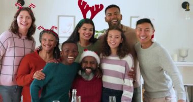 Noel 'i kutluyoruz, farklı ailelerden insanlar şenlikli şapkalar takıyor ve evde neşeyle gülüyorlar. Kutlama, tatil, mutluluk, gelenek, çok kültürlü, kış