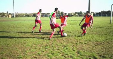 Futbol oynuyorlar, erkek oyuncular kale kenarına oturmuş dinleniyorlar. Spor, takım çalışması, sporcular, rahatlama, rekabet, eğlence
