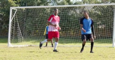 Futbol oynamak, açık havada güneşli bir günde maçta gol atan çocuklar. Takım çalışması, spor, saha