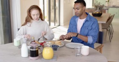 Çeşitli çiftler kahvaltıda gözleme ve meyve yiyor, evde gülümsüyorlar. Aile, aile, sabah, yemek, yaşam tarzı, mutluluk.